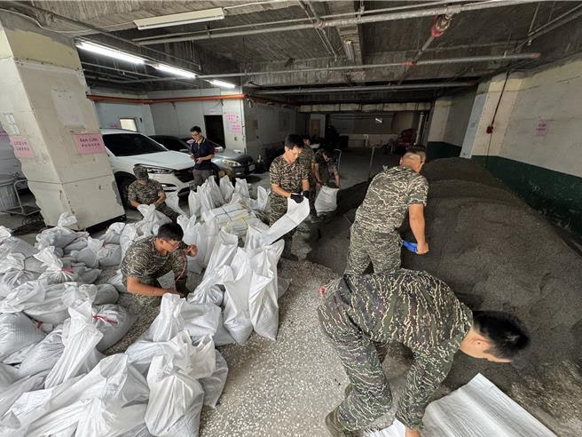 上次凯米颱风酿三民区大淹水，这次民眾不敢掉以轻心要领沙包防灾，却因领取的人太多不够用，区公所急调度国军弟兄协助包装沙包。（民眾提供／任义宇高雄传真）