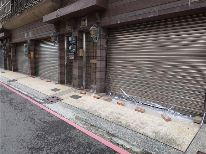 民眾在透天门口铺防水帆布，避免淹水灌进屋内。（任义宇摄）