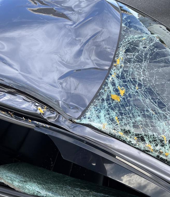 有駕駛今上午開車行經國道1號遭到標誌牌擊中，愛車擋風玻璃、右側車窗及車頂受損。（國道警方提供／呂筱蟬桃園傳真）