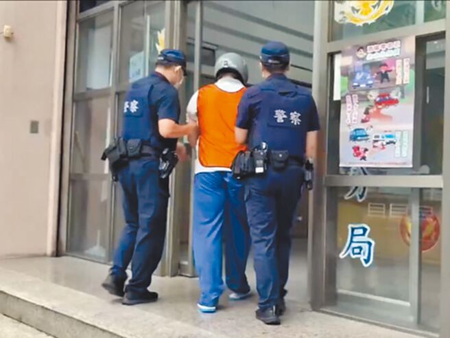 鄭姓男子（中）情緒失控持刀殺死母親，警方將他帶回警局偵訊。（民眾提供／郭良傑高雄傳真）