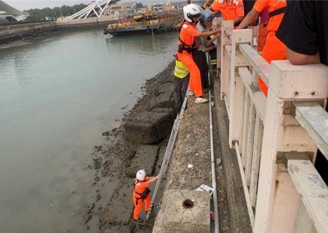 颱風來襲男子永安漁港海堤釣魚受困 ，海巡偕同消防員合力救援。(海巡署提供／呂筱蟬桃園傳真)