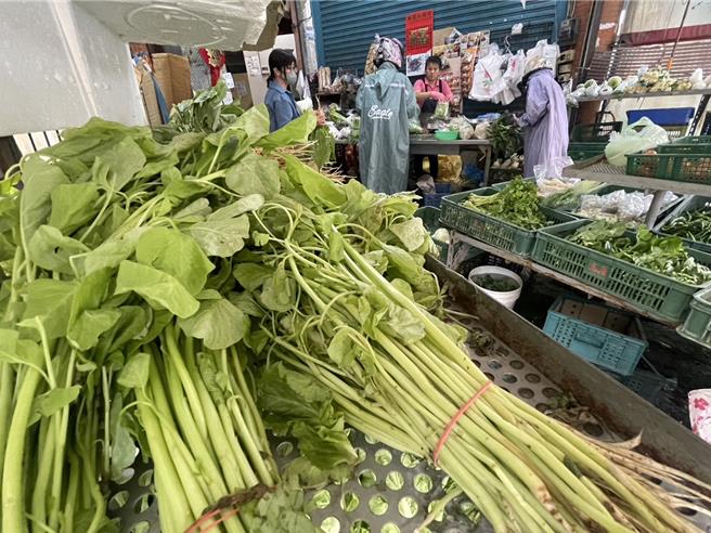 颱風接力報到讓菜價直直漲，民眾趁雨較小到市場買菜。（孫英哲攝）