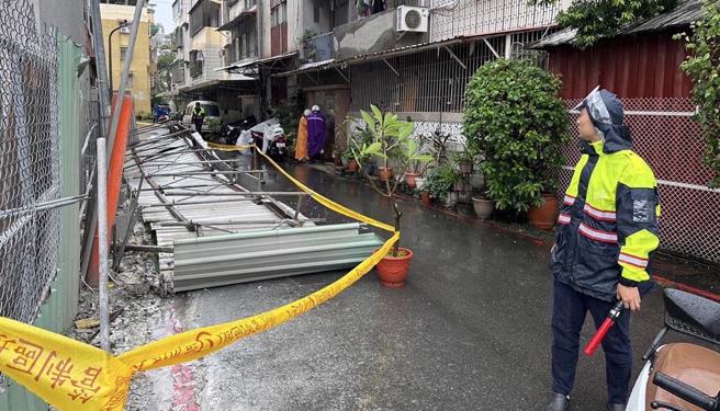 警方到圍籬倒塌現場交管，所幸沒有造成人員受傷，施工單位已承諾會賠償受損機車。（警方提供／任義宇高雄傳真）