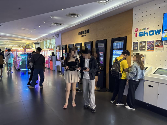 正巧颱风假又赶上强檔电影上映，民眾「把握机会」，男朋友牵着穿短裙女朋友买票看电影。（高钧麟摄）