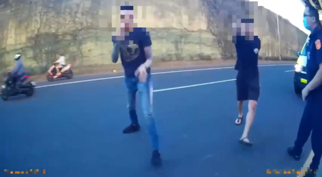 蔡、陈二人不断逼近警消，其中一名刺青男子甚至如同被激怒的袋鼠握紧双拳，摆出圣战士的姿态后，在现场「跳来跳去」。（图 / 刘咏韵翻摄）