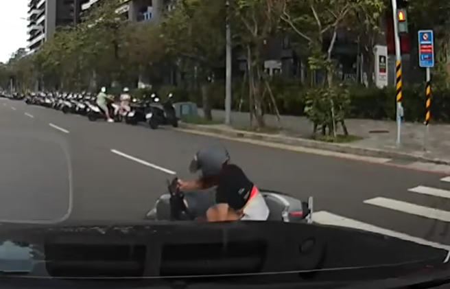 昨日淡水区有女骑士不敌强风被吹倒，后方驾驶见状，赶紧下车帮忙解围。（图／翻摄自我是新庄人许明伟）