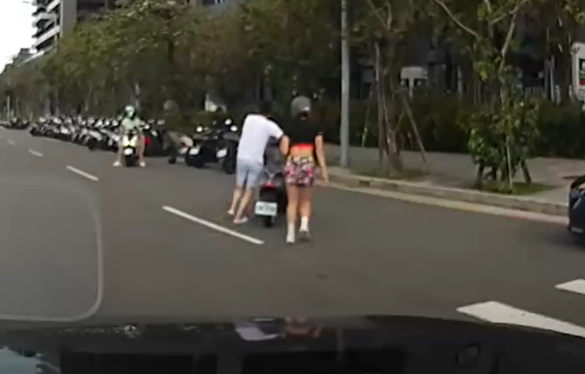 昨日淡水区有女骑士不敌强风被吹倒，后方驾驶见状，赶紧下车帮忙解围。（图／翻摄自我是新庄人许明伟）