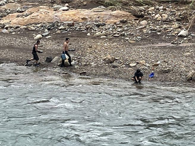 新北市員山子分洪道今（2）日上午出現3名男子不畏山陀兒颱風帶來的風雨、帶著簡易工具「淘金」，轄區瑞芳警分局獲報後前往勸離。（翻攝畫面）