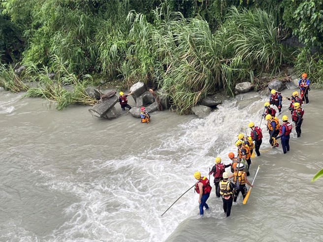 花莲美崙溪上游水源桥下方，今下午疑似老翁落水意外，警消人员赶往搜救，颱风来，溪水混浊湍急。（王志伟摄）