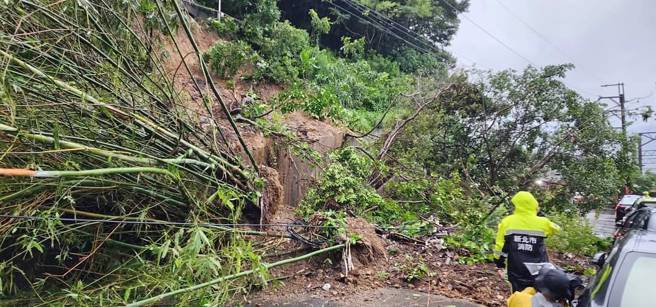 大量土石沿着山壁倾泻而下，泥流以及倾倒的树木直接覆盖在道路上，警消封闭双向道路。(翻摄自记者爆料网)
