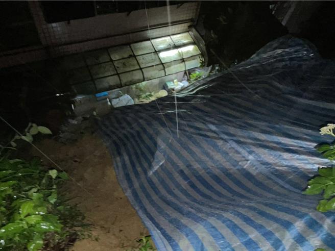 基隆市信義區東信路一處民宅後方發生小規模土石流，造成民宅後門遭土石堵住，市府緊急鋪設帆布因應。（翻攝照片／張志康基隆傳真）