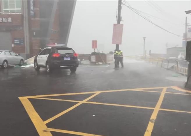 兩名警員要綁封鎖線被強風吹到完全站不穩。（民眾提供／郭良傑高雄傳真）