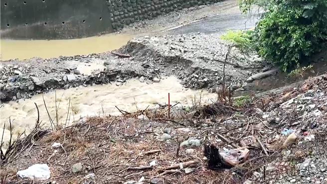 滚滚泥流夹带土石及残枝覆盖路面，泥流深度达脚踝以上。（萧嘉蕙摄）