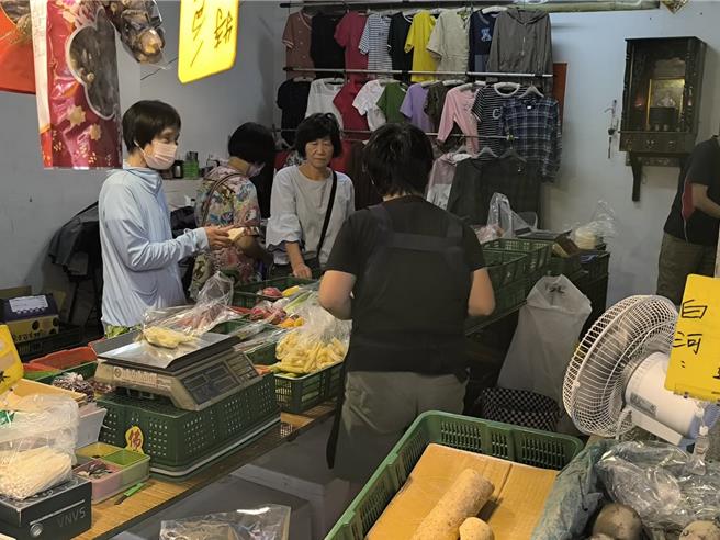 民眾逛市場買青菜。（李京昇攝）