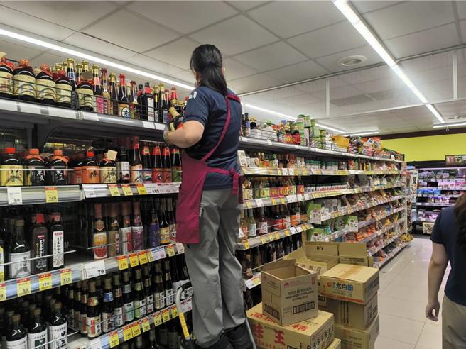 超市賣場人員忙著補貨。（李京昇攝）