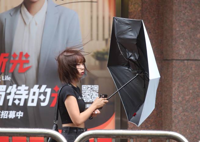 颱風山陀兒來襲，台北市區出現間歇性雨勢及強風，依舊讓外出民眾吃足苦頭，傘花頻頻開。（劉宗龍攝）
