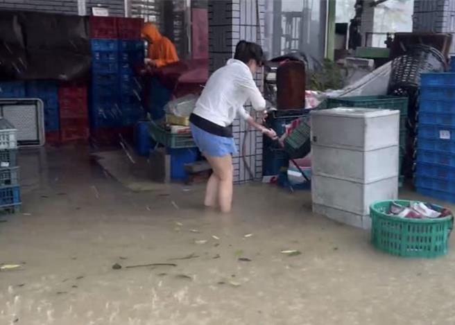 内惟市场做生意的住户忙着将物品搬到高处。（郭良杰摄）