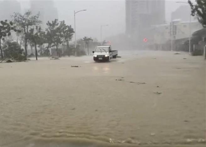 货车强行通过淹水的道路。（郭良杰摄）