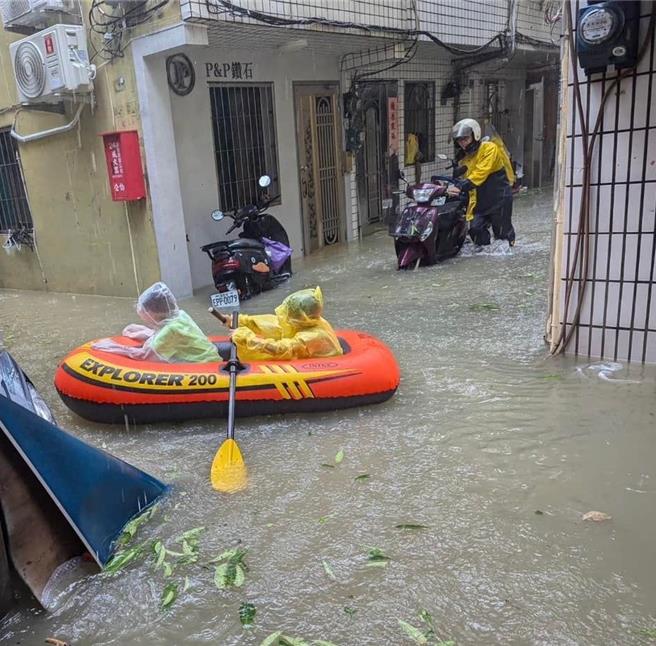 高雄三民区中华横路一带，有民眾拍下，小朋友划着「玩具橡皮艇」漂浮在淹水的巷弄中。（民眾提供／纪爰高雄传真）