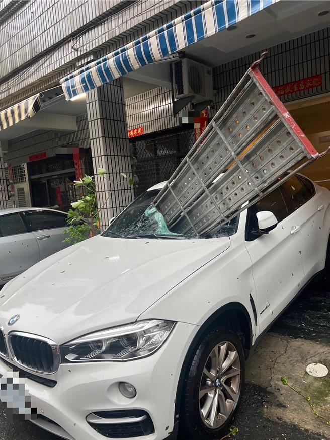 前鎮區一輛停放在住家樓下的名車，被不知從何飛來的工地鷹架棧板砸中。（翻攝照片／洪靖宜高雄傳真）