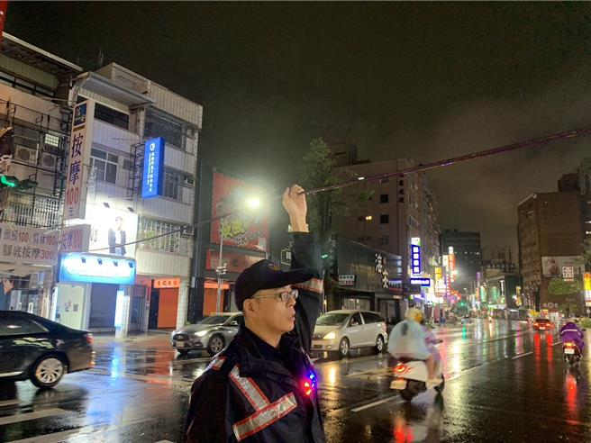 员警将电缆线撑住。（郭良杰摄）