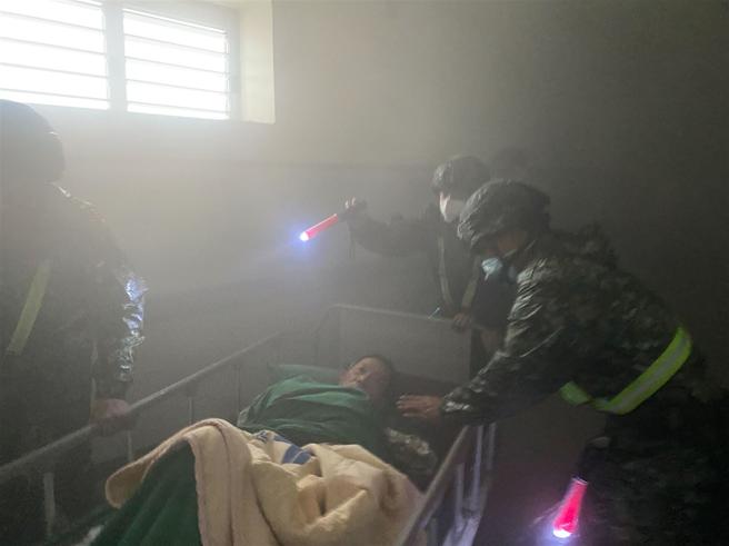 机步333旅官兵至病房内协助人员撤离、疏散，以确保病患安全。（第4作战区提供）