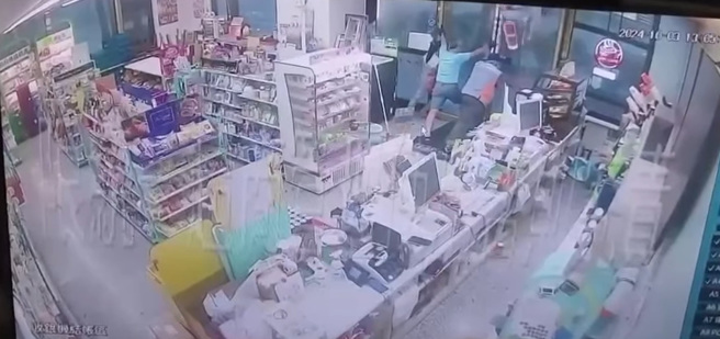 某间超商店员本想撑住玻璃门，却连门一同被强风吹飞。（图／翻摄自脸书「爆料公社」）