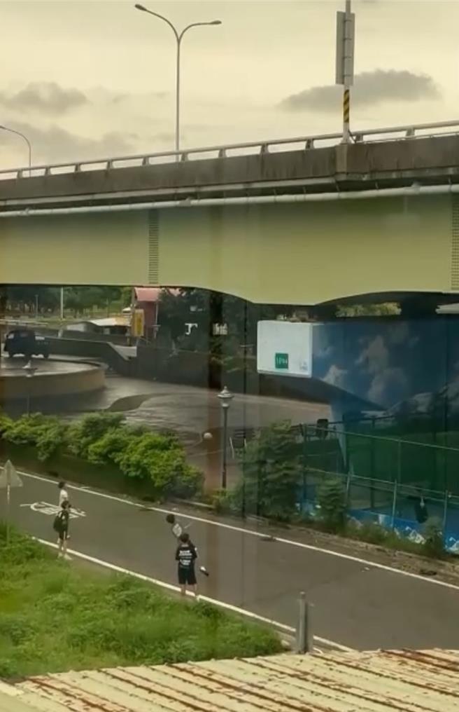 台中市3日因应山陀儿颱风袭台停班停课，不过天气尚佳，大里区中投公路下就出现4名青少年打篮球，却是在车道上拿篮球丢掷高架桥桥墩，时不时有机车经过，相当惊险。（民眾提供／潘虹恩台中传真）