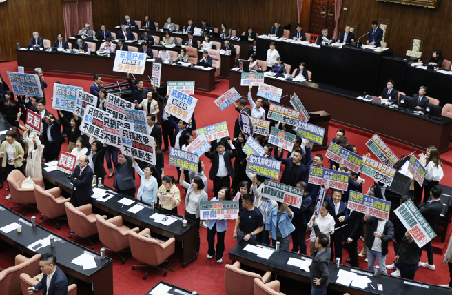 针对中央政府总预算案，立法院4日院会表决，蓝白以人数优势在表决中通过民眾党团提案，总预算再度遭到退回程委会，民进党立委高举「只搞政争，不顾民生」等标语抗议（左），国民党立委高举「支持原民支持农民」等标语，要求行政院重编总预算（右）。（姚志平摄）