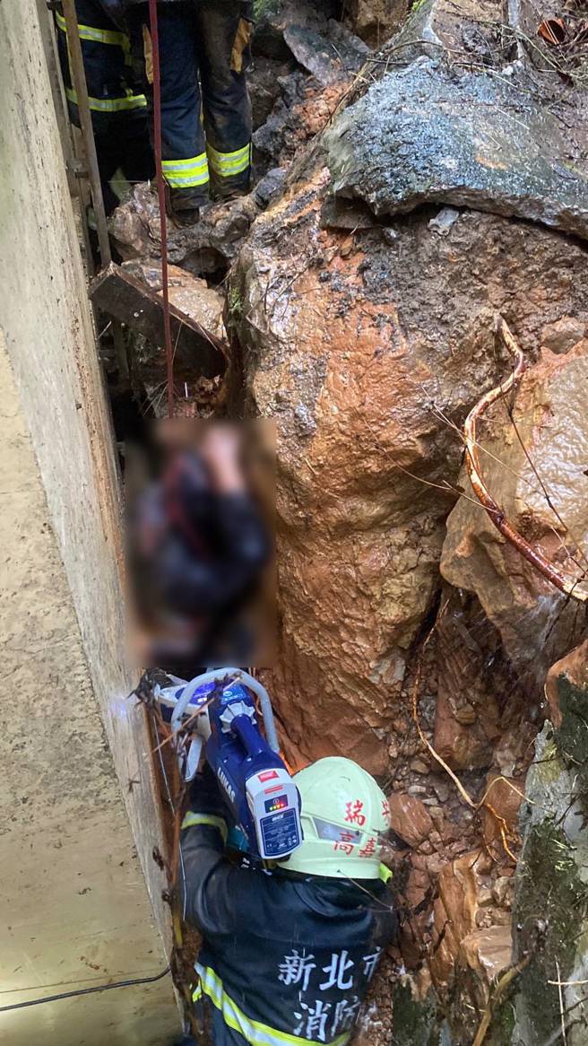 万里老翁因为住家后挡土墙崩落，导致脚部被夹住受困，消防队获报到场救援。（翻摄画面）