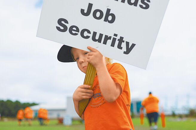 国际码头工人协会（ILA）的港口工人在美国维吉尼亚州参加罢工，图为一名儿童举着标语。（路透）