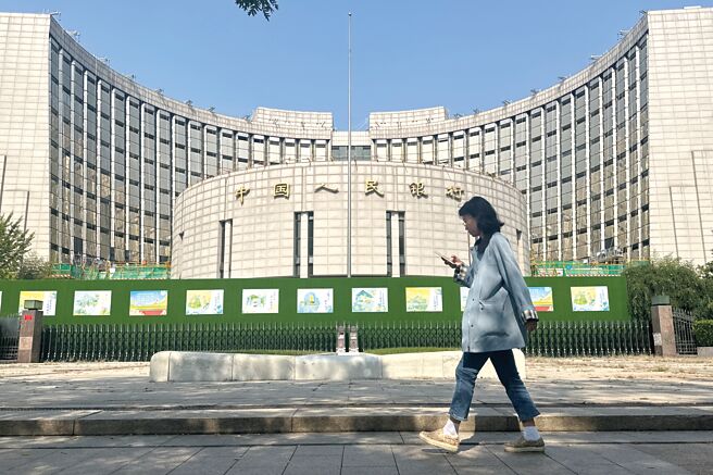 全球主要經濟體降息使人民幣匯率面臨的外部壓力明顯減輕。圖為大陸民眾經過位於北京的中國人民銀行。（中新社）