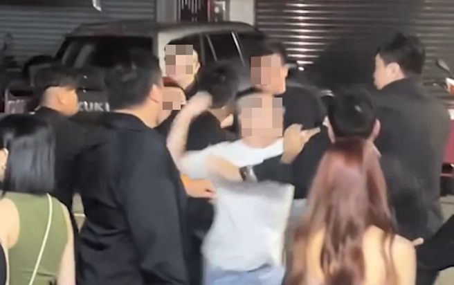 身穿白衣的男子與一群保安起口角，隨後雙方便爆發肢體衝突。（圖／翻攝記者爆料網）