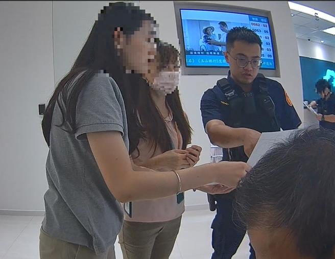 警方与行员联手阻诈，向男子解说假投资诈骗手法。（翻摄照片／林郁平台北传真）