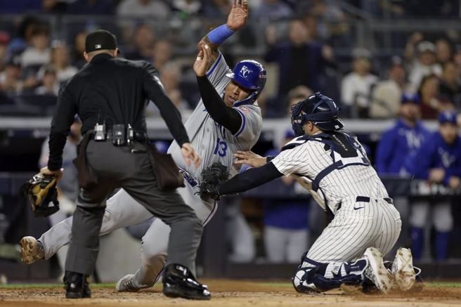 皇家裴瑞兹(中)衝本垒遭到洋基捕手威尔斯触杀出局。（美联社）