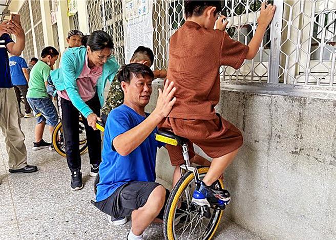 新竹縣兒童專注力與情緒管理訓練的獨輪車邁入第七屆，愛心志工老師訓練孩子如何先在獨輪車上坐好。（羅浚濱攝）