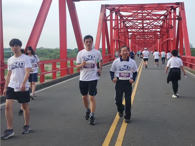 西螺大桥风景优美很适合路跑，图为县议员李明哲与西螺七崁武术文教基金会董事长丁振源边聊边跑。（周丽兰摄）
