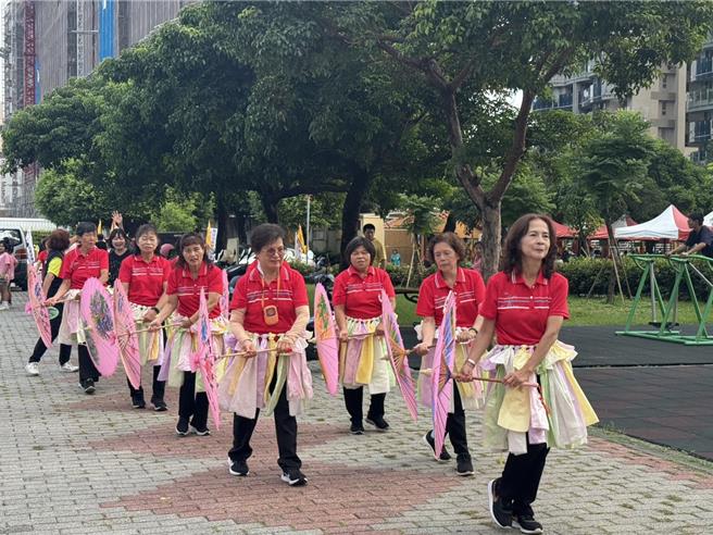 台中市烏日區光明、三和、榮和、湖日和學田5社區共同推動大旗艦計畫，6日在榮和公園朥（月胥）福德廟舉辦成果發表，逾百位居民在音樂與鼓聲中踩街遊行，氣氛歡樂。（潘虹恩攝）