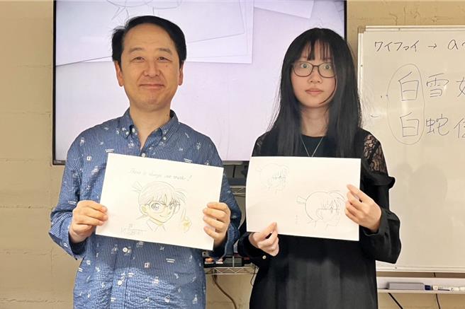 弘光科大学生陈昀萱（右）习作受到动漫大师小幡公春（左）称讚，获赠亲笔签名作品。（校方提供／李京升台中真）