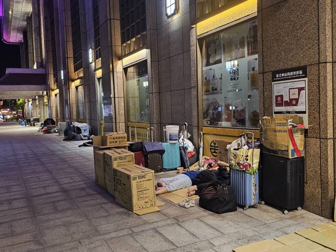北车街友躺睡国门市容惹争议。（记者游定刚拍摄）