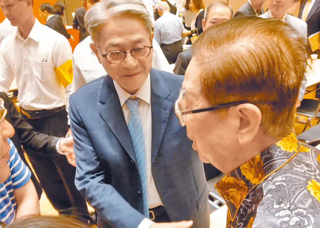 台新金董事长吴东亮（左）在股东会上向阿土伯致意。（资料照片）