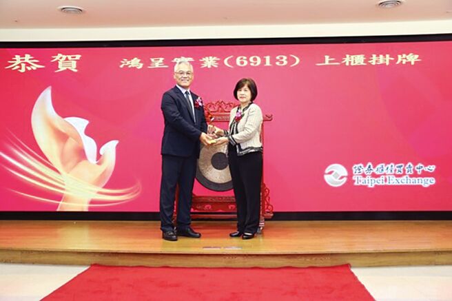 柜买中心总经理陈丽卿（右）致赠纪念品予鸿呈董事长简忠正（左），恭贺上柜挂牌。图／柜买中心提供