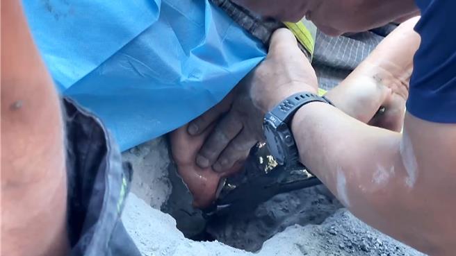 消防队员使用削岩机破坏阿公手臂周围的水泥，协助脱困。（读者提供／萧嘉蕙台东传真）