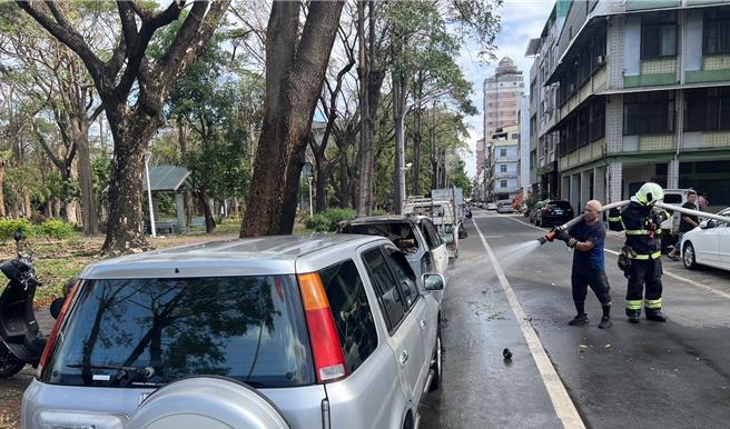 消防队员喷水灭火时，热心民眾上前协助。（民眾提供／郭良杰高雄传真）