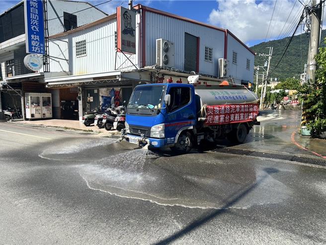 往返卑南乡及台东市间的千岁桥道路泥泞不堪，民进党台东县党部8日集资清洗周边道路。（民进党台东县党部提供／蔡旻妤台东传真）