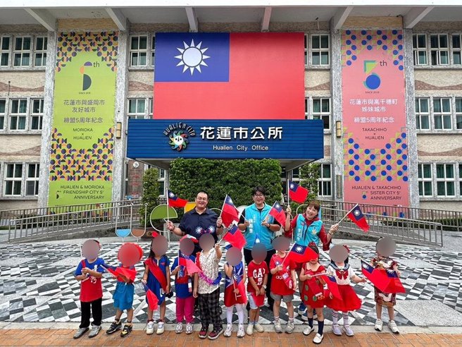 花莲市公所悬挂大幅国旗迎双十国庆，市长魏嘉彦（中）今与花莲市幼儿园小朋友戴着国旗帽、穿上红白蓝配色的服装，挥舞国旗，庆祝中华民国的生日。（花莲市公所提供／王志伟花莲传真）