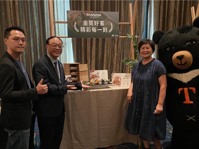 宜兰「逢春园渡假别墅」获评为金质好客民宿，负责人许丽华（右）与儿子林嵩浩（左）在展摊前合影。（陈佑诚摄）