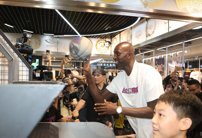 贾奈特与小球迷玩起投篮游戏，最终小球迷获胜。(黄邱伦摄)