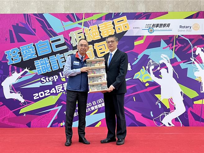  刑事局副局长黄壬聪颁赠感谢奖牌给国际扶轮社3522地区总监侯玳梁。（翻摄照片／林郁平台北传真）