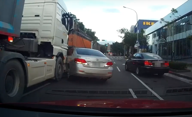 有轿车打了方向灯就切车道，导致被卡在2辆砂石车中间。（图／翻摄自WoWtchout - 地图型行车影像分享平台）